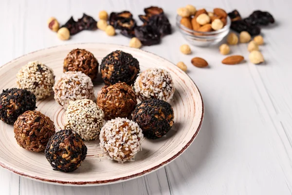 Bolas energéticas de frutos secos, avena y frutos secos en un plato sobre fondo blanco, orientación horizontal — Foto de Stock