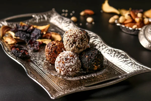 Energy balls of nuts, oatmeal and dried fruits on a metal tray on a dark background, horizontal orientation — Stock Photo, Image
