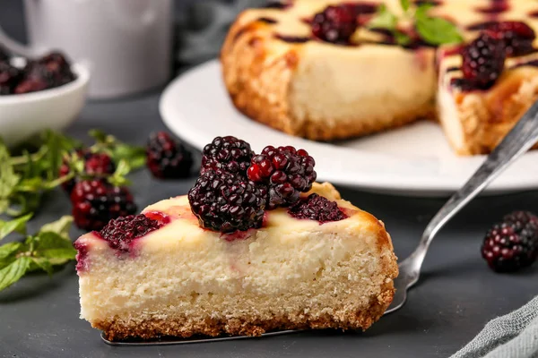 Homemade cottage cheese cake with blackberries with a cut piece of cake located on a dark background, horizontal orientation — Stock Photo, Image