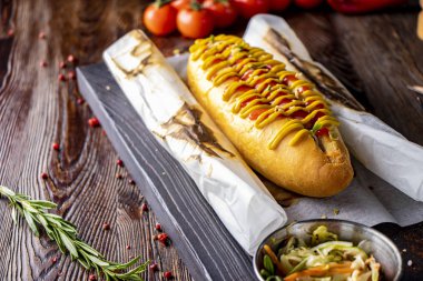 Sosisli sosisli, koyu bir arka plan, rustik tarzı, yatay yönelim karşı ahşap bir tahta üzerinde yer almaktadır