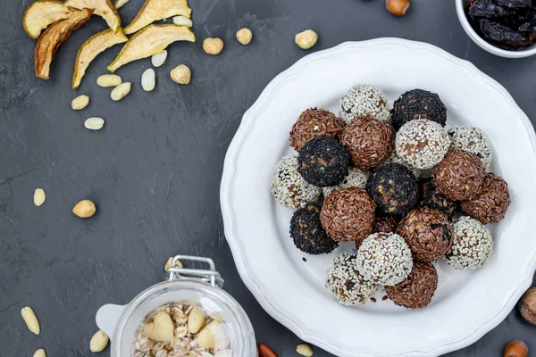 Bolas de energía de frutos secos, avena y frutos secos en un plato sobre fondo oscuro, orientación horizontal — Foto de Stock