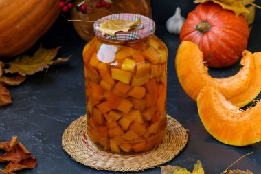 Koyu bir arka plan üzerinde bulunan kavanozda adet kabak, kış için sebze hasat, yatay oryantasyon