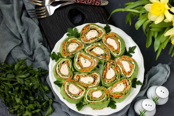 Rollo de lavash con palitos de cangrejo, espinacas, perejil y zanahorias en estilo coreano en un plato sobre un fondo oscuro, orientación horizontal, vista superior —  Fotos de Stock