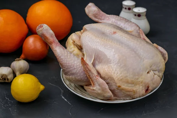 Rohes Huhn zum Backen im Ofen mit Honig, Orangen, Zitronen und Knoblauch, dunkler Hintergrund, horizontale Ausrichtung — Stockfoto