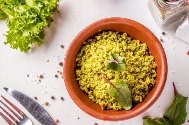 Kuskus, zeytinyağlı kase ve beyaz arka planda kurutulmuş domates, doğu mutfağı, yatay yönelim, üst görünüm.