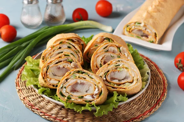 Açık mavi arkaplanda ringa balığı, patates ve soğan, yatay formatta Pita rulosu