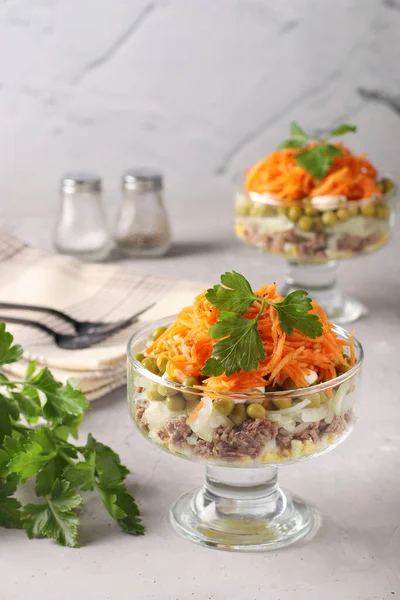Salată cu morcovi coreeni, carne și mazăre conservată în boluri transparente de salată un fundal gri deschis — Fotografie, imagine de stoc