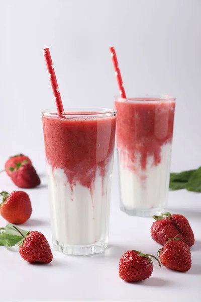 Zwei Portionen hausgemachte Doppelschicht-Smoothies mit frischen Erdbeeren, Minze und Joghurt in Gläsern auf weißem Hintergrund, Diät- und Gewichtsreduktionskonzept — Stockfoto