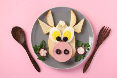 Komik bir boğa şeklinde sosisli ve yumurtalı sandviç. Pembe arka plan 2021 'in sembolü. Çocuklar için aşçılık fikri.