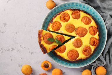 Kayısılı cheesecake, mavi tabakta ve bir fincan kahvede, yatay formatta, boşluğu kopyala