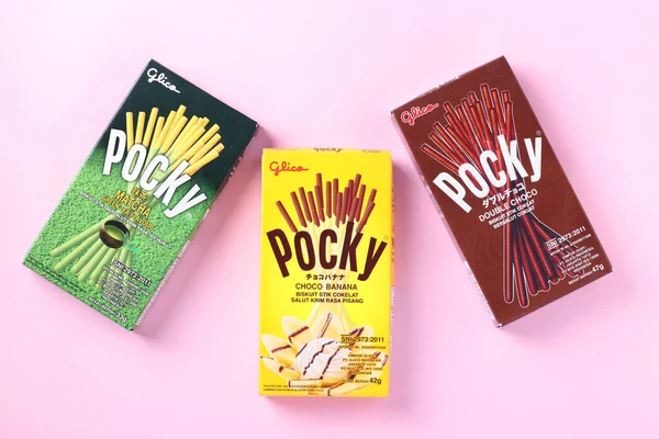 Pembe zemin üzerinde muz, çikolata ve kibrit çöpleri olan pocky marka, Asyalılar arasında ünlü şekerlemeler, 30 08 2020 Ukrayna, Kremenchuk