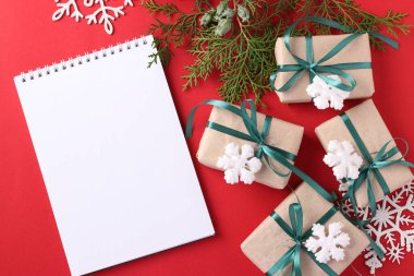 Kırmızı yüzeyi yeşil kurdeleli Noel hediyesi kutuları. Dilekler için yer. Tatil kartı. Üst görünüm.