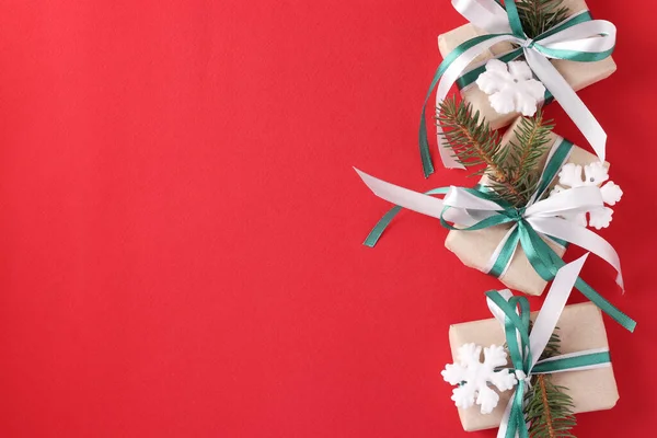 三个圣诞礼品盒 红色表面有绿色和白色的缎带 度假卡顶部视图 案文的篇幅 — 图库照片