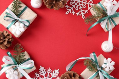 Noel çerçevesinde hediyeler, toplar, kırmızı arka planda kar taneleri. Tebrik kartı. - Mutlu yıllar. Mesaj için yer var. Düz yatıyordu. Xmas.