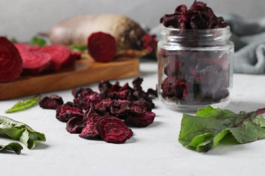 Sağlıklı ev yapımı pancar cipsi ve gri arka planda pancar. Yakın çekim..