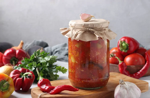 Patlıcan, havuç, biber, soğan ve domatesli sebze salatası tahta tahtada cam kavanozda, yatay formatta.