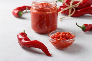 Geleneksel acı biberli sos eklentisi, hafif arka planda harissa ezmesi. Tunus, Gürcü ve Arap mutfağı. Yatay biçim.