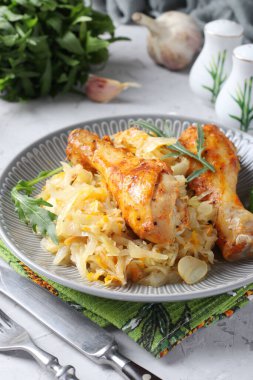 Lahanalı tavuk budu ve gri tabakta sarımsak. - Yakın çekim. Dikey biçim.