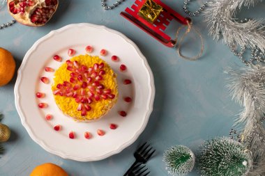 Tavuklu, yumurtalı, havuçlu ve mısırlı yeni yıl salatası, beyaz tabakta nar tohumlarından bir yıldız ile süslenmiş,
