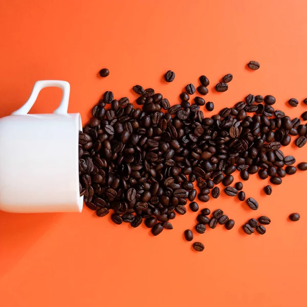 Grãos de café em xícara de café isolado em branco — Fotografia de Stock