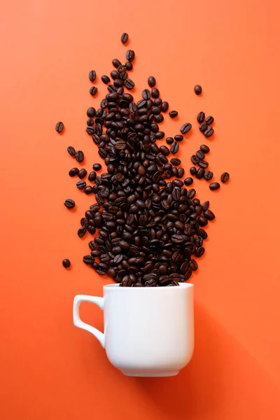 Grãos de café em xícara de café isolado em branco — Fotografia de Stock