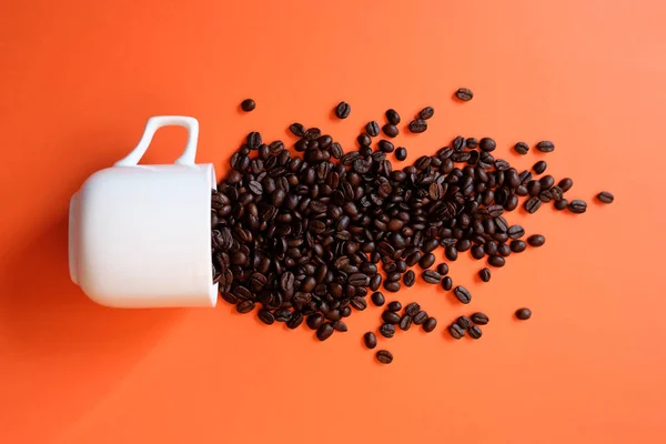 Grãos de café em xícara de café isolado em branco — Fotografia de Stock