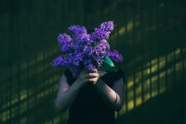 Girl holding lilac bouquet in front of face — Stock Photo, Image