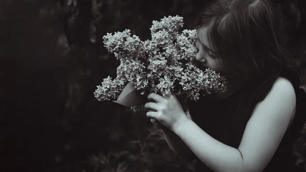 Menina bonito cheirando lilás — Fotografia de Stock