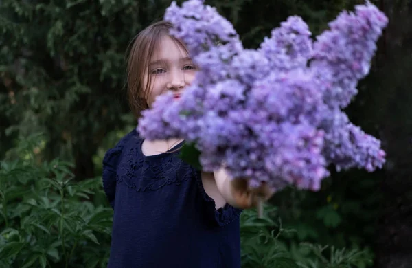 Fille cachant visage avec bouquet lilas — Photo