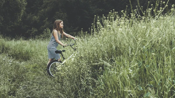 Çizgili elbiseli kız bisikletsürme — Stok fotoğraf