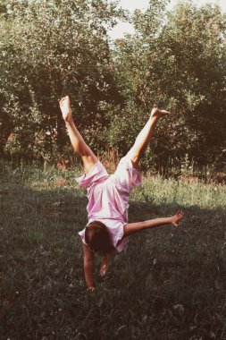 Pembe elbiseli genç kız baş aşağı duruyor