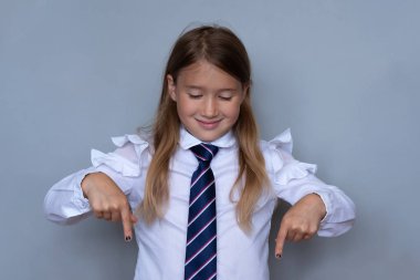Küçük kız öğrenci portre aşağı işaret