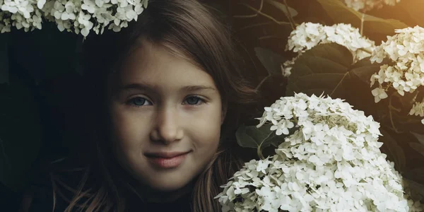 Menina bonito cheirando lilás — Fotografia de Stock