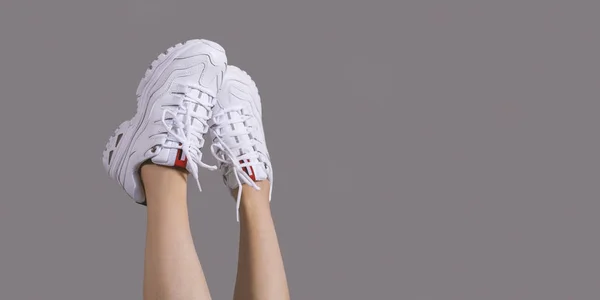 Woman in stylish sneakers near color wall, closeup. — Stock Photo, Image