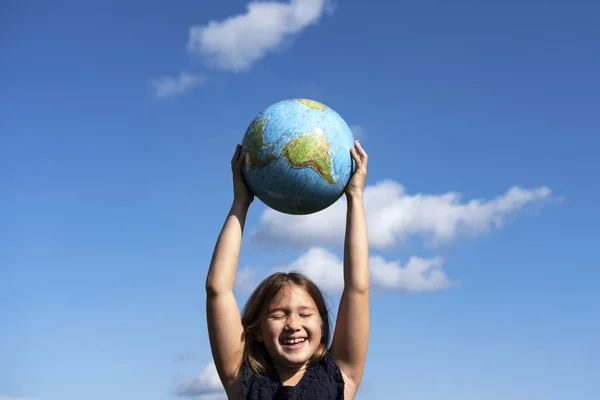 Usmívající se dívka držící planetu Zemi — Stock fotografie
