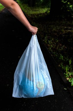 El plastik torba açık havada Dünya küre tutarak