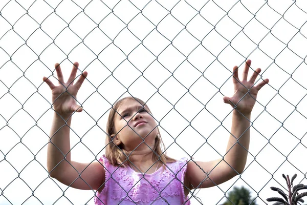 Metal tel örgü çit arkasında Üzgün kız — Stok fotoğraf