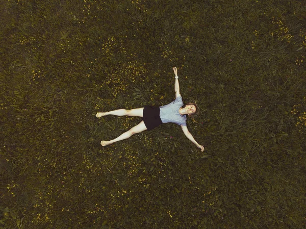 40 ans femme couchée sur l'herbe verte dans le parc — Photo