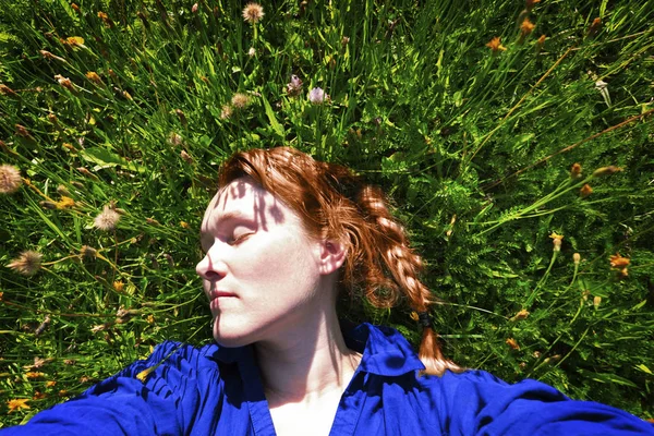 40 years old woman lying on green grass in park — Stock Photo, Image