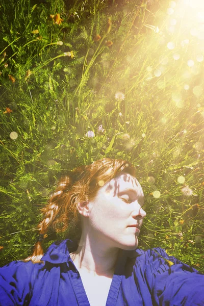 40 anos de idade mulher deitada na grama verde no parque — Fotografia de Stock