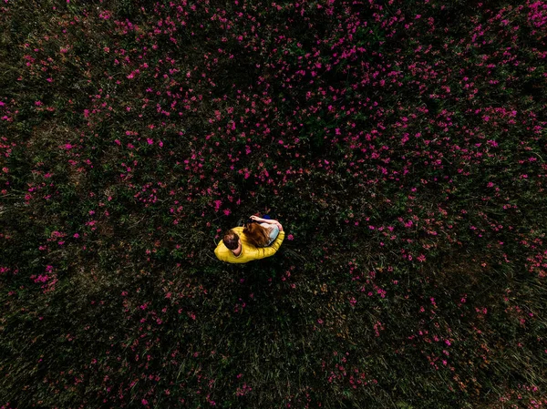 Parkta yeşil çimlerde oturan kadın ve adam — Stok fotoğraf