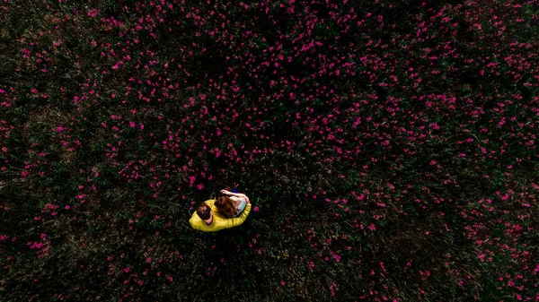 Žena a muž sedí na zelené trávě v parku — Stock fotografie