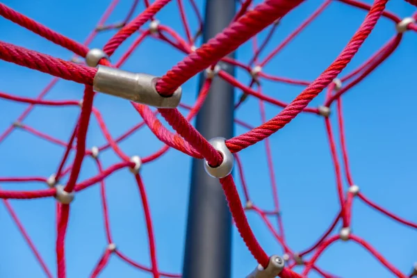 Red ropes on playground against the blue sky