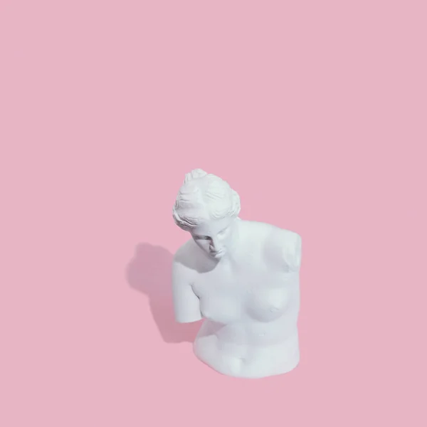 Pembe arka planda beyaz kadın heykeli