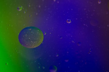 Bardaktaki berrak suda sebze yağı kabarcıkları ve renkli kağıttaki kızartma tavasının şeffaf kapağı..