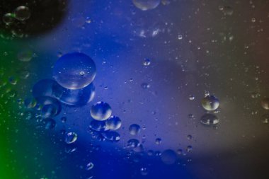 Bardaktaki berrak suda sebze yağı kabarcıkları ve renkli kağıttaki kızartma tavasının şeffaf kapağı..