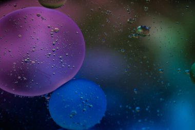 Bardaktaki berrak suda sebze yağı kabarcıkları ve renkli kağıttaki kızartma tavasının şeffaf kapağı..