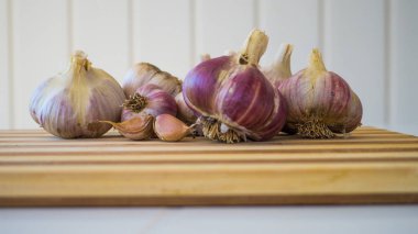 Güzel, taze ve taze sarımsak bahçeden çıkartılır ve tahta bir kalasın üzerinde yatar..