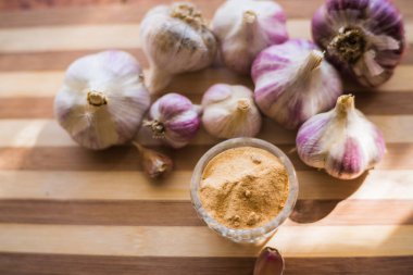 Kahverengi ahşap bir tahtanın üzerinde sarımsak aromalı güzel ve büyük sarımsak..