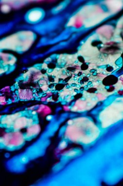 Mavi ve pembe mürekkep beyaz lavaboya dökülmüş ve mürekkep soyut damlalara ve desenlere karışmış..